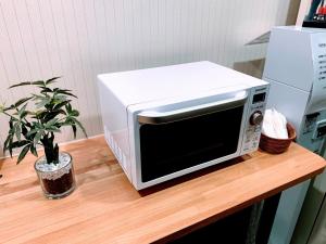 un microondas sentado en la parte superior de un mostrador con una planta en Hakodate Hotel Ekimae - Vacation STAY 91712v, en Hakodate