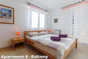 a bedroom with a large bed with purple pillows at Art Apartments Vrsar in Vrsar