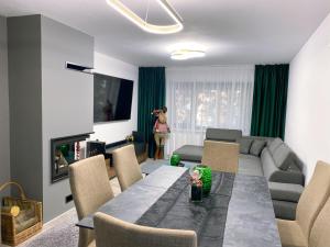 a living room with a table and a couch at Villa Virginia in Broşteni