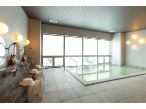 Großes Zimmer mit einem großen Fenster sowie Tischen und Stühlen. in der Unterkunft ＨＯＴＥＬ ＴＲＵＮＫ ＷＡＫＫＡＮＡＩ - Vacation STAY 92551v in Wakkanai