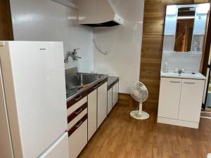 uma pequena cozinha com um lavatório e um frigorífico em Kura "Ika" - Vacation STAY 95263v em Nagahama