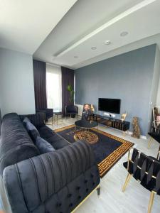 ein Wohnzimmer mit einem großen Sofa und einem TV in der Unterkunft Burgaz in Esenyurt