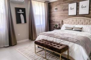 Dormitorio con cama con banco en Apartamento Vacacional en Montego Bay Jamaica, en Kingston