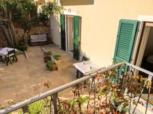 a garden area with a patio and a balcony at Il Giardino Rooms & Breakfast in La Maddalena