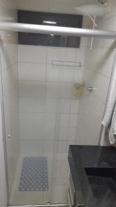 um chuveiro com uma porta de vidro na casa de banho em Apt. encantador 50m da praia de Ponta Verde em Maceió