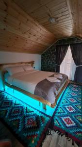 sypialnia z łóżkiem w drewnianym suficie w obiekcie The Village House w mieście Korcza