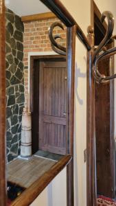 drewniane drzwi w pokoju z ceglaną ścianą w obiekcie The Village House w mieście Korcza