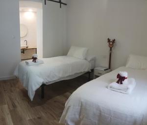 1 dormitorio con 2 camas y toallas. en Alojamiento El Morico, en Casas de Juan Núñez
