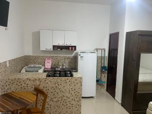 a small kitchen with a stove and a refrigerator at Studio a 100m da praia - VILA PAITITÍ in Fortaleza