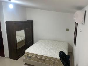 een slaapkamer met een bed en een dressoir met een spiegel bij Studio a 100m da praia - VILA PAITITÍ in Fortaleza