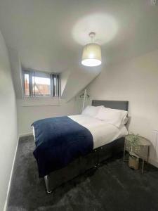 a bedroom with a large bed with a blue blanket at 5. Homely Cecil Apartments in Birmingham