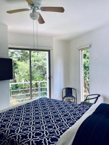 ein Schlafzimmer mit einem Bett und einem großen Fenster in der Unterkunft Residencial Bali Casa Mariposa in Playa del Carmen