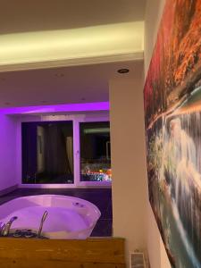 e bagno con vasca e illuminazione viola. di Checkmate a Tešanj