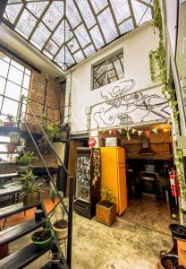 a shop with a yellow refrigerator in a room with plants at Casa Mutante in Montevideo