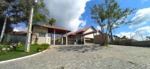 a house with a brick driveway in front of it at Casa em Condomínio Montserrat in Guaramiranga