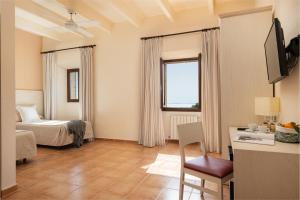 a hotel room with a bed and a desk and a window at Santuari de Cura in Randa