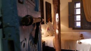 a bedroom with a bed and a door with a mirror at Riad Nafis in Marrakech