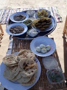 Golden nubian guesthouse في أسوان: طاولة عليها عدة أطباق من الطعام