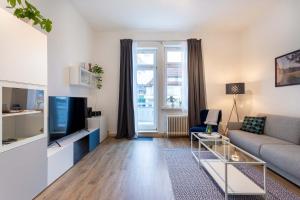 a living room with a couch and a tv at Apartment 54 - Ferienwohnung Bad Arolsen in Bad Arolsen