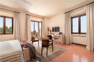 a bedroom with a bed and a desk with a computer at Santuari de Cura in Randa