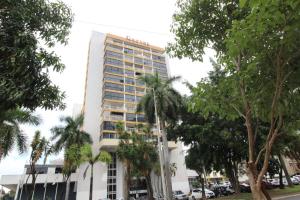 un edificio alto con palmeras delante en Garvey Park Hotel, en Brasilia