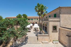 an external view of a building with a palm tree at Santuari de Cura in Randa
