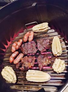 a grill with a bunch of different types of meat and vegetables at Quirquincho House in Puerto Maldonado