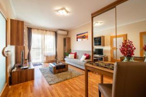 sala de estar con sofá y espejo grande en Santos 1214 Apartment, en Budapest