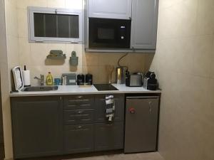 a small kitchen with a sink and a microwave at casa de los amigos in Tías +5 photos