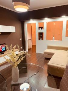 Una sala de estar con un sofá y un jarrón con flores. en A casa Con....TE!, en Nápoles