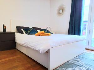 Una cama blanca con toallas en un dormitorio en L'Orée du Marais - Paisible maison centre-ville en Bourges
