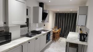 a kitchen with white cabinets and a counter top at DaySpring White House - Dartford Kent in Kent