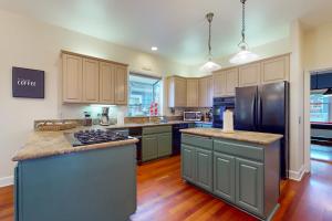 cocina grande con suelo de madera y electrodomésticos de acero inoxidable en Westside Sanctuary en Seattle