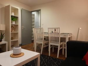 L'Orée du Marais - Paisible maison centre-ville في بورج: غرفة معيشة مع طاولة طعام وكراسي