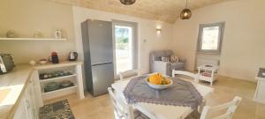 a kitchen with a table with a bowl of fruit on it at Trullo Mamamè in Cisternino