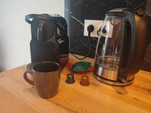 - une cafetière et une tasse sur un comptoir en bois dans l'établissement Le Champêtre, à Nancy