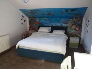 een slaapkamer met een bed met een vismuurschildering aan de muur bij Modern 3 bedroom house with a private pool in Popeşti-Leordeni