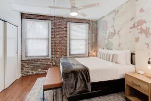 a bedroom with a bed and a brick wall at Historic Details Modern Updates in Prime Location in Memphis