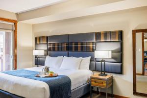 una habitación de hotel con una cama y una mesa con un plato de comida en Stoneridge Mountain Resort, en Canmore