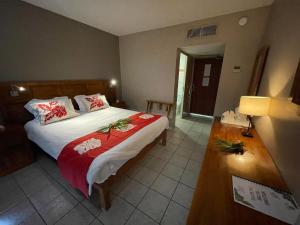 1 dormitorio con 1 cama y 1 mesa con lámpara en Tiki Hôtel - Hôtel d'application du Lycée de Tahiti en Punaauia