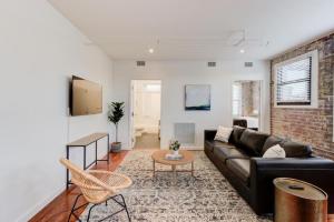 a living room with a black couch and a brick wall at Modern Apartment in Historic Shell in Memphis