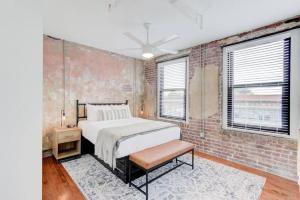 a bedroom with a bed and a brick wall at Historic Vibe on Main St in Memphis
