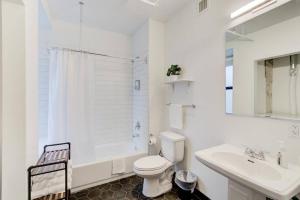 a white bathroom with a toilet and a sink at Right on Main St with Historic Vibe! in Memphis +30 photos