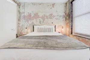 a bedroom with a large white bed with two lamps at Historic Revival Downtown in Memphis