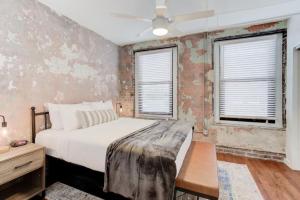a bedroom with a bed and two windows at Historic Apartment in Prime Location in Memphis