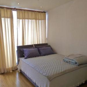 Yujeong Guesthouse في جيونجو: غرفة نوم مع سرير مع وسائد أرجوانية ونافذة