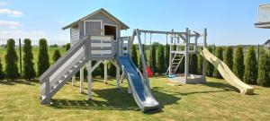 two slides and a play structure in a yard at Domki letniskowe HOLIDAY in Ustronie Morskie