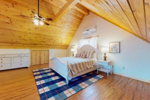 ein Schlafzimmer mit einem Bett und einer Holzdecke in der Unterkunft Lake Therapy Hideaway in New Tazewell