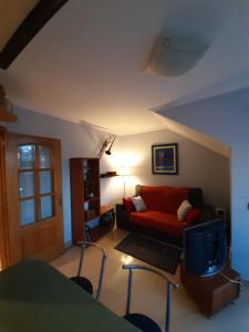 a living room with a red couch and a table at APARTAMENTO CORTEGADA in Vilagarcia de Arousa