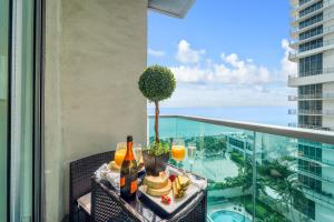 a table with food and drinks on a balcony with the ocean at Extraordinary Oceanfront Condo - Heated Pool, Gym and Game Room - Hollywood Beach in Hollywood +33 photos